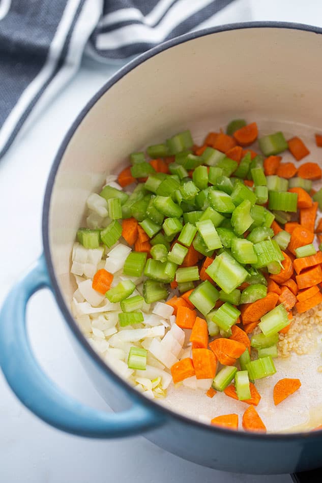 Sautéed onions, garlic, celery and carrots in a blue pot