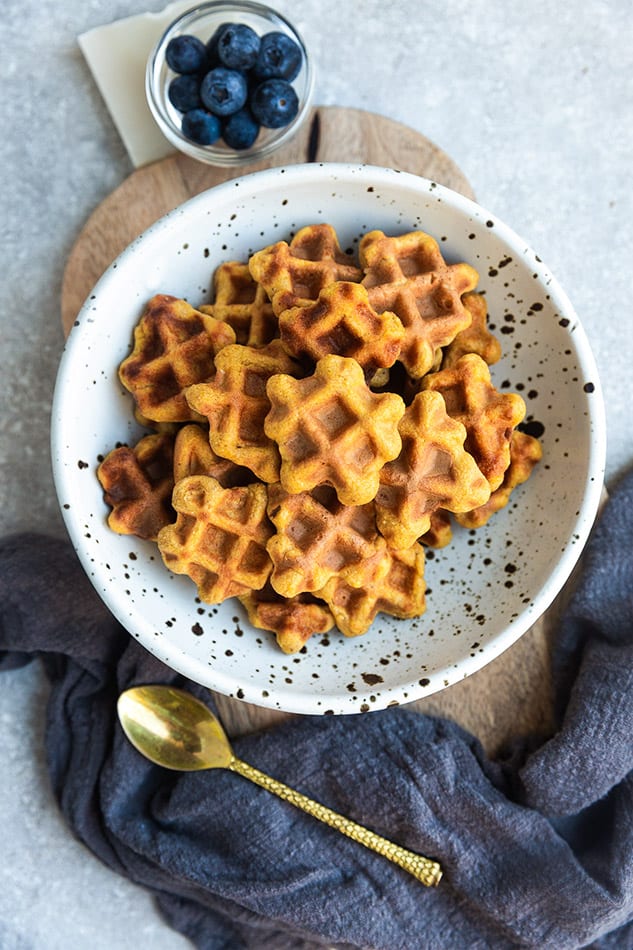 Overhead image of waffle cereal placed in white bowl with black speckles.