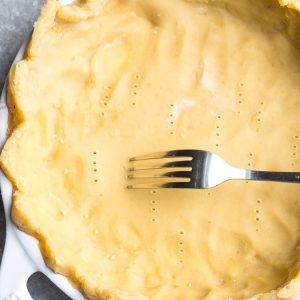 Unbaked keto pie crust with fork piercing