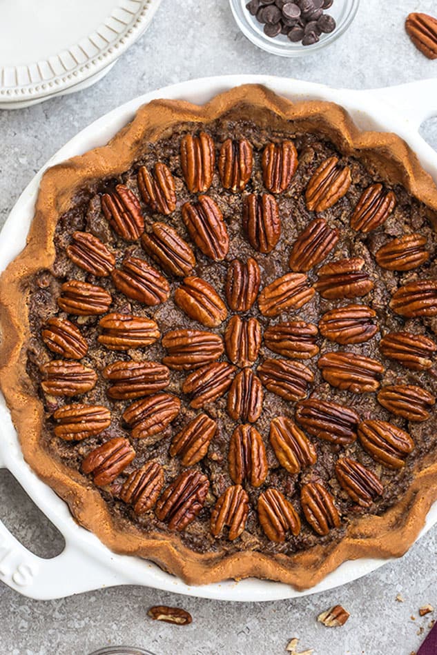 Close-up view of Keto Pecan Pie in a white pie pan on a grey background