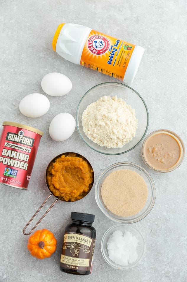 Top view of ingredients to make low carb keto pumpkin cookies with chocolate chips on a grey background