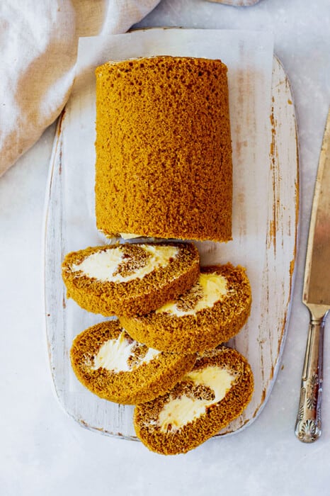 Top close-up view of four slices of easy pumpkin cake roll on a white oval platter