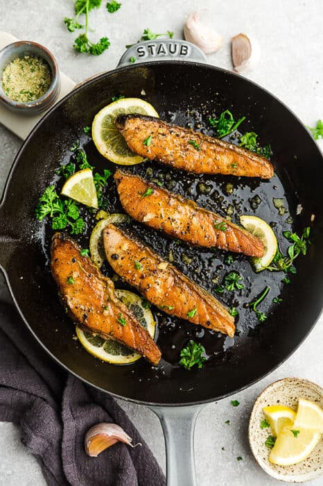 Top view of broiled salmon in a cast-iron skillet