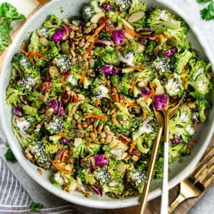 Top view of Keto broccoli salad in a white bowl with gold spoons