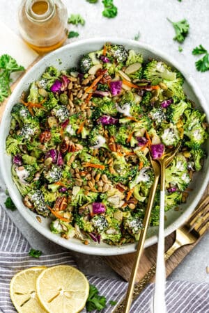 Top view of Keto broccoli salad in a white bowl with gold spoons