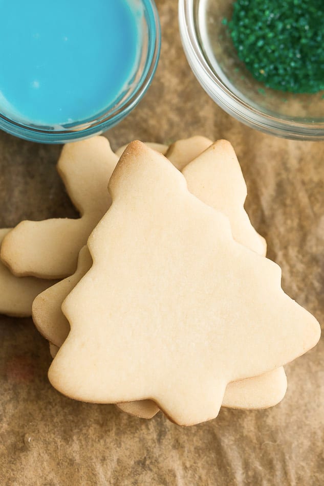 Top view of a stack of Keto Sugar Cookies next to colorful icing