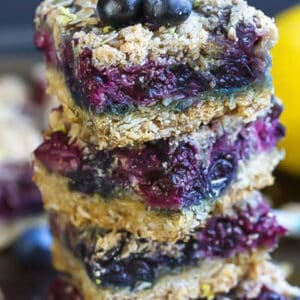 Pinterest image with one stack of lemon blueberry bars with fresh blueberries.
