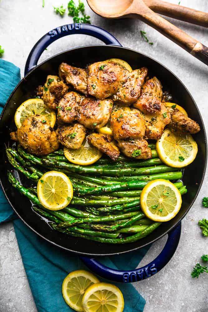 Lemon Garlic Chicken with asparagus and lemon slices in a skillet