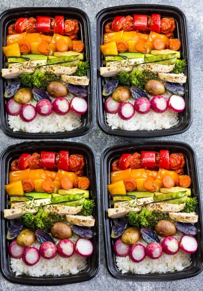 Four meal prep containers of Lemon Herb Chicken with Rainbow Vegetables over rice
