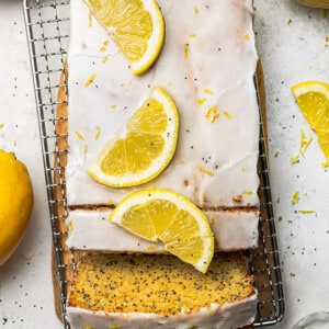 Flat lay of a lemon loaf with two slices on a wire rack