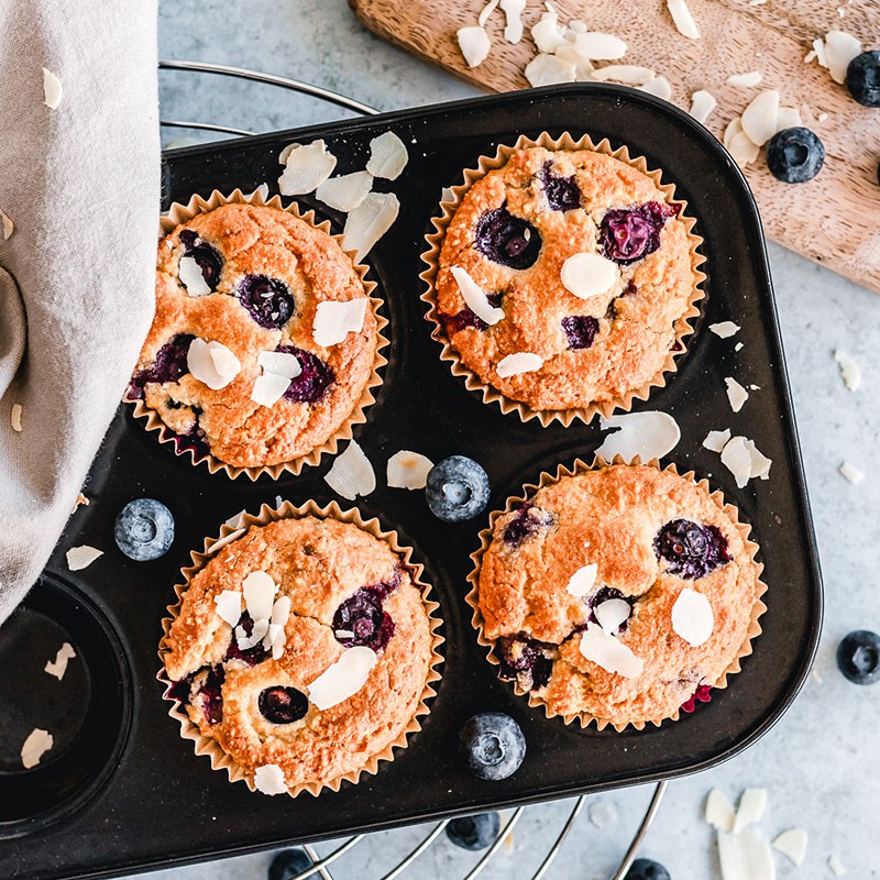 Top view of a muffin tin with four Keto Blueberry Muffins