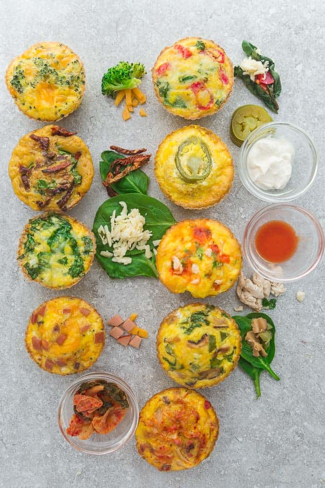 Nine Breakfast Egg Muffin Cups on a Granite Countertop with Various Dips and Ingredients in Small Cups