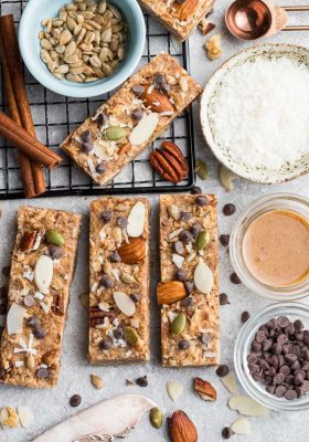 Top view of 4 keto granola bars on a grey background with ingredients