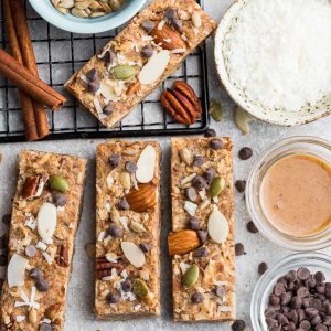 Top view of 4 keto granola bars on a grey background with ingredients