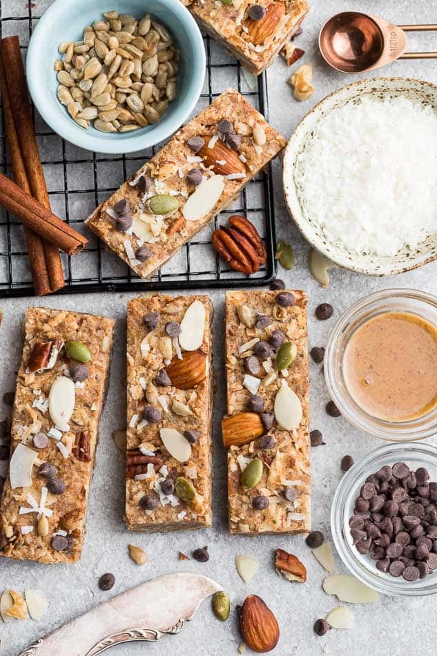 Top view of 4 keto granola bars on a grey background with ingredients