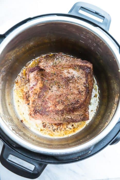A Seasoned Chuck Roast in the Bowl of an Instant Pot After it's Been Browned