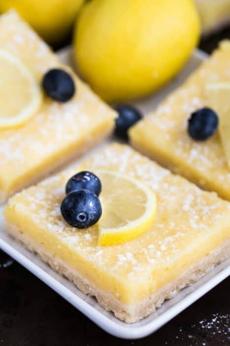 Low Carb Keto Lemon Bars on a white square plate with one blueberry