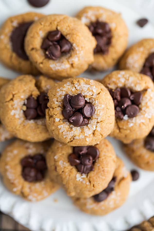 Top view of a full pile of keto peanut butter blossoms on a white plate