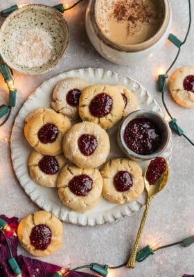Top view of keto shortbread thumbprint cookies on a white plate with strawberry chia jam