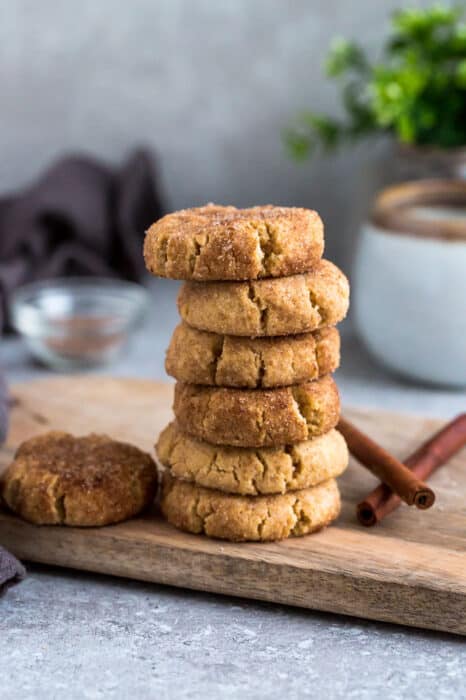 Side view of 6 stacked low carb paleo soft snickerdoodle cookies on a wire rack on a grey background