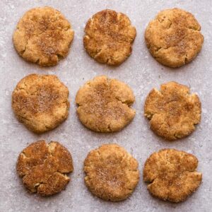 Top view of 9 keto snickerdoodles on a grey background