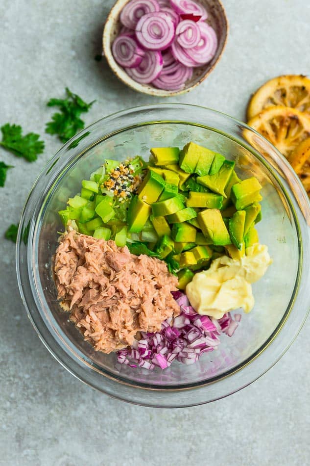 Chopped avocado in a mixing bowl with Whole30 mayo, diced red onion and the remaining ingredients