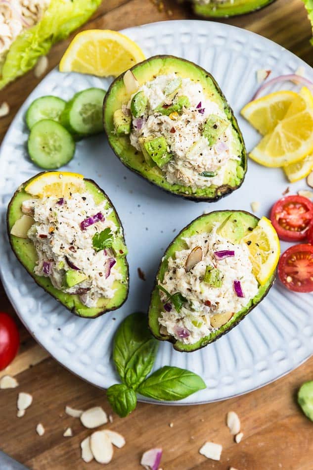 Top view of Whole30 classic chicken salad in 3 avocado halves on a white plate