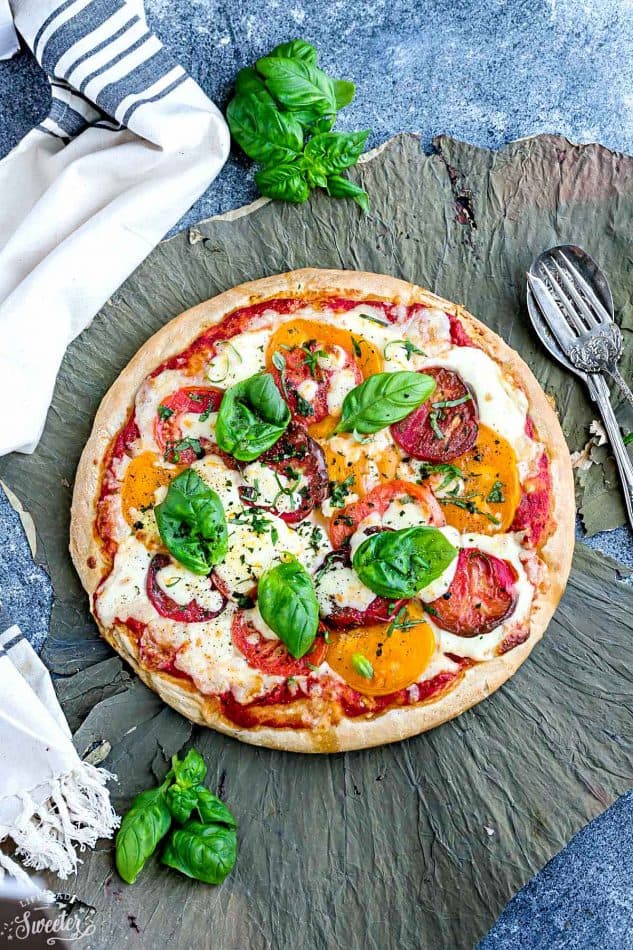 Margherita Pizza - a simple classic recipe that's made with Heirloom tomatoes, mozzarella and fresh basil. Easy and perfect for busy weeknights. Best of all, simple to customize with your favorite toppings