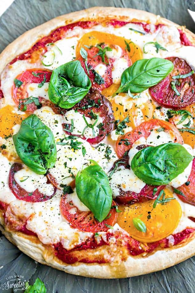 Margherita Pizza - a simple classic recipe that's made with Heirloom tomatoes, mozzarella and fresh basil. Easy and perfect for busy weeknights. Best of all, simple to customize with your favorite toppings