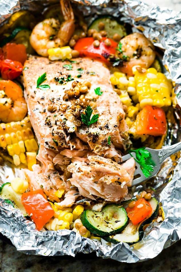 Close-up of a Mediterranean Salmon Foil Packet with lentils, shrimp and vegetables