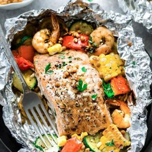 Top view of a foil packet with Mediterranean salmon with shrimp and vegetables