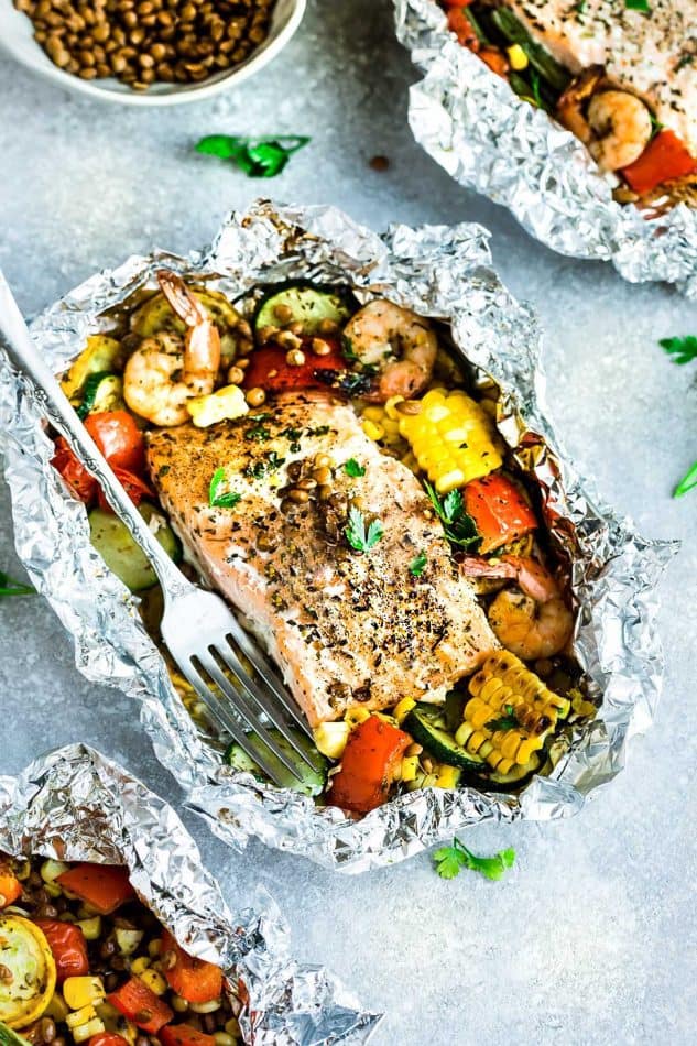 Top view of a foil packet with Mediterranean Salmon surrounded by shrimp and vegetables