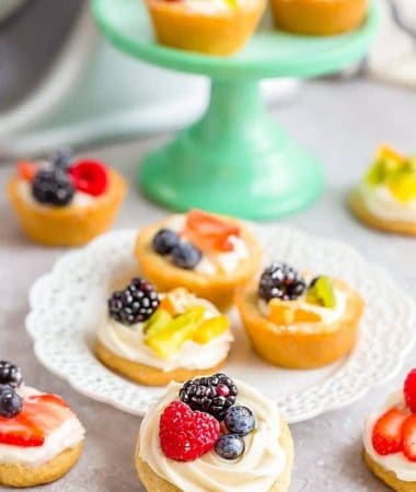 Mini Fruit Pizza desserts scattered on and around a dessert plate