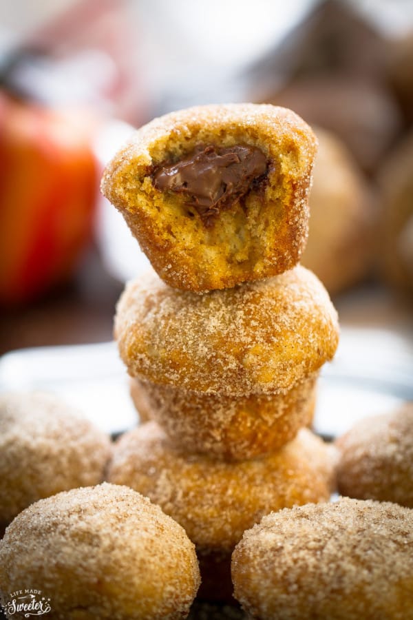 A stack of Mini Pumpkin Nutella Donut Muffins with a bite out of the top one