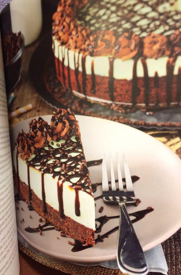 A slice of Mint Andes Chocolate Brownie Cheesecake on a plate with a fork