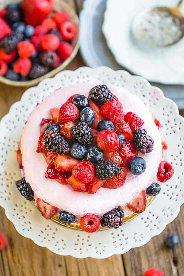 Top view of Keto Cheesecake decorated with mixed berries on a white plate