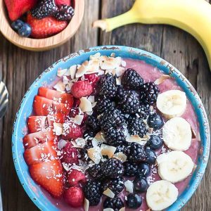 Top view of a Mixed Berry Detox Smoothie Bowl next to berries and a banana