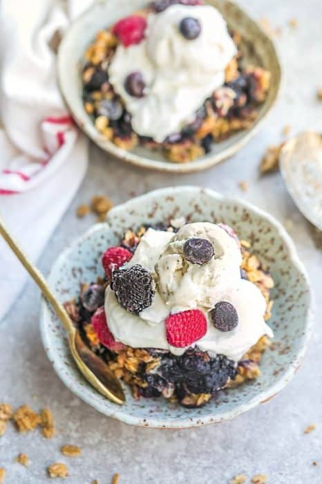 Small bowl of delicious Mixed Berry Skillet Crisp with a golden spoon.