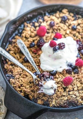Easy Mixed Berry Skillet Crisp in a cast iron skillet with vanilla ice cream on top.