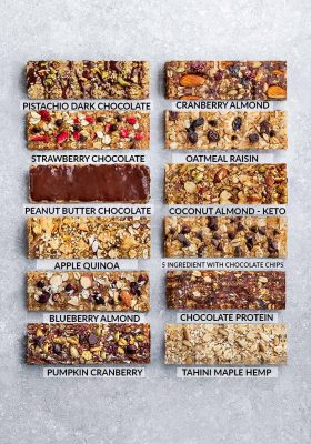 12 Granola Bars Lined up on a Gray Counter with Flavor Labels on Each One