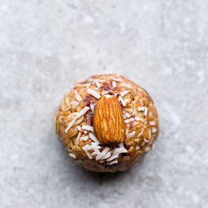 A Coconut Almond Butter Energy Ball Sitting on a Gray and White Countertop