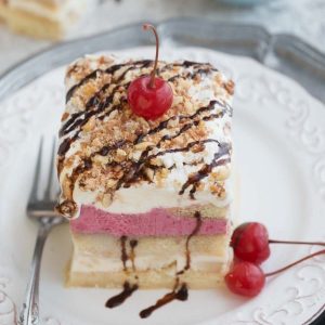 A square of Banana Split Tiramisu on a white plate with a fork