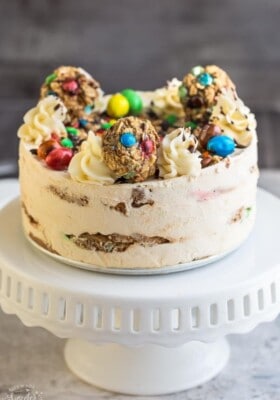 Side view of a whole no bake cookie cake on a white cake stand
