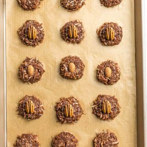 Top view of 16 decorated Keto No Bake Cookies on a brown parchment paper on a baking sheet