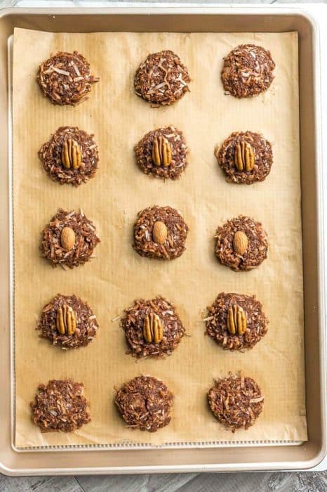Top view of 16 decorated Keto No Bake Cookies on a brown parchment paper on a baking sheet