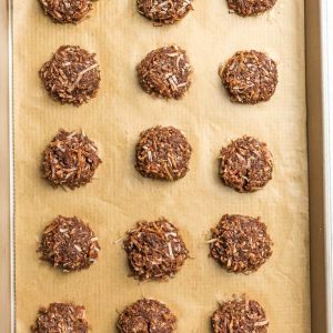 Top view of 16 undecorated Keto No Bake Cookies on a brown parchment paper on a baking sheet