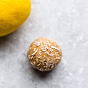 A Lemon Protein Ball Beside a Fresh Lemon on a Countertop