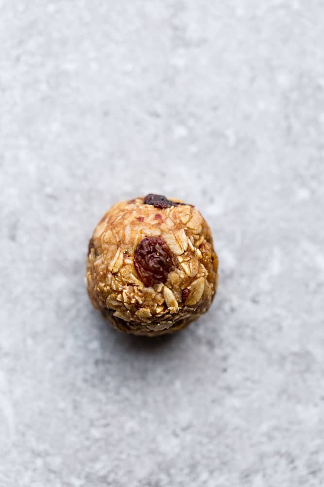 one no bake oatmeal raisin protein bite on a marble counter top
