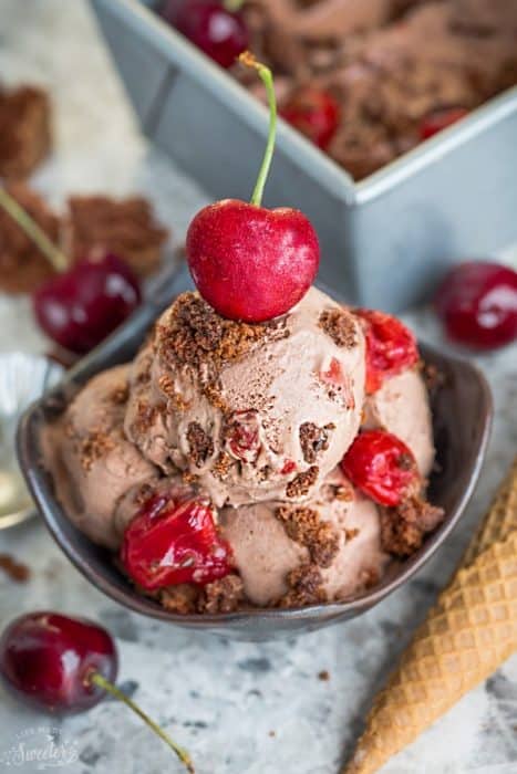 A bowl of No Churn Black Forest Ice Cream topped with a cherry