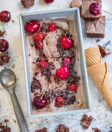 No Churn Black Forest Ice Cream in a pan with a scoop and cones alongside